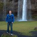 Jeremy stands in front of a waterfall.